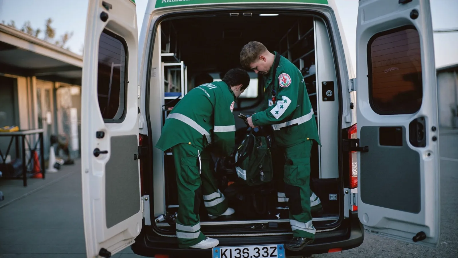 Two paramedics checking equipment in the back of an ambulance at the start of a shift