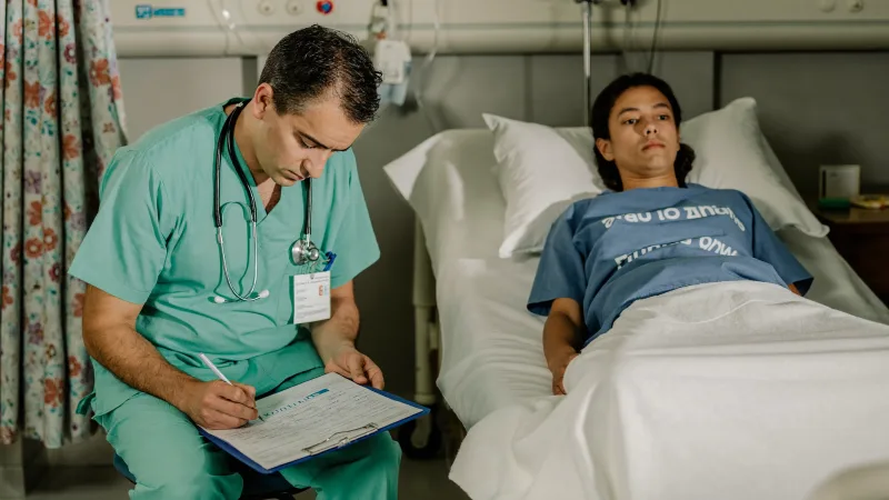 A physician associate taking a patient history in a hospital assessment area