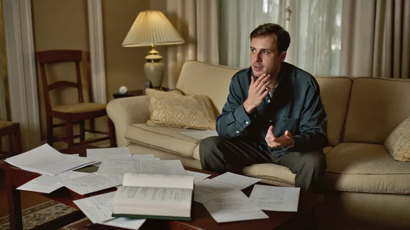A candidate rehearsing interview answers with handwritten notes spread on a table